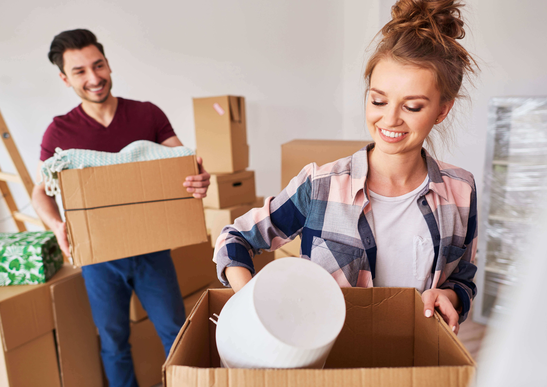 happy couple smiling and packing boxes