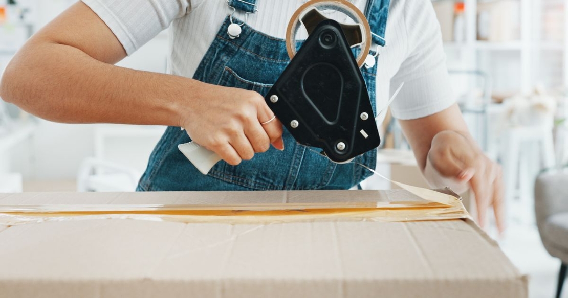 Woman using tape gun when packing