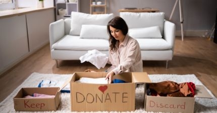 Women with keep, donate and discard boxes